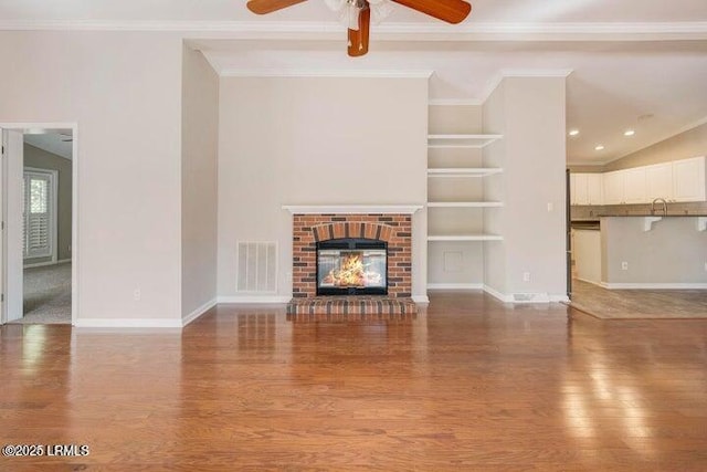 1 Wateree Ct, Beaufort, SC 29902 - unfurnished living room featuring ceiling fan, wood finished floors, a brick fireplace, ornamental molding, and built in features