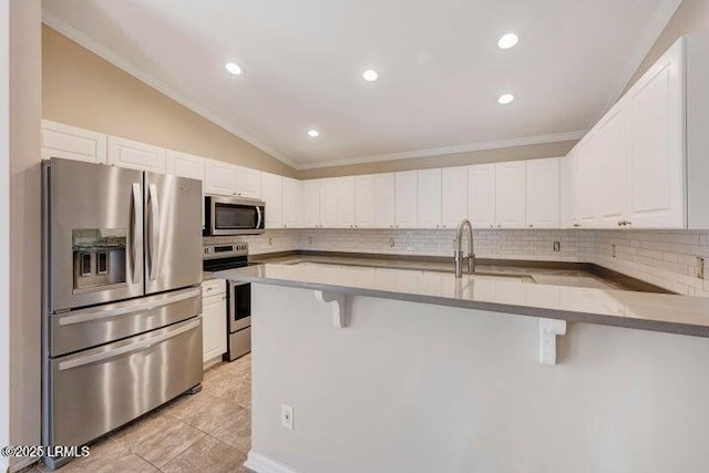 1 Wateree Ct, Beaufort, SC 29902 - kitchen with stainless steel appliances, a kitchen breakfast bar, decorative backsplash, white cabinets, and vaulted ceiling