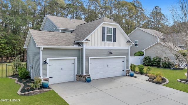 view of side of property with a lawn, board and batten siding, driveway, and fence