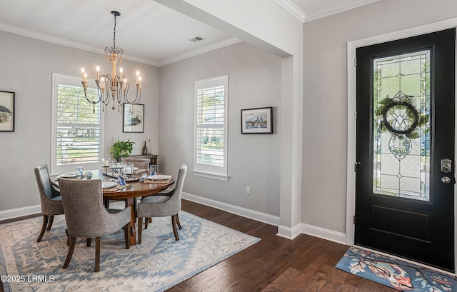 dining space featuring dark hardwood / wood-style flooring, ornamental molding, and an inviting chandelier