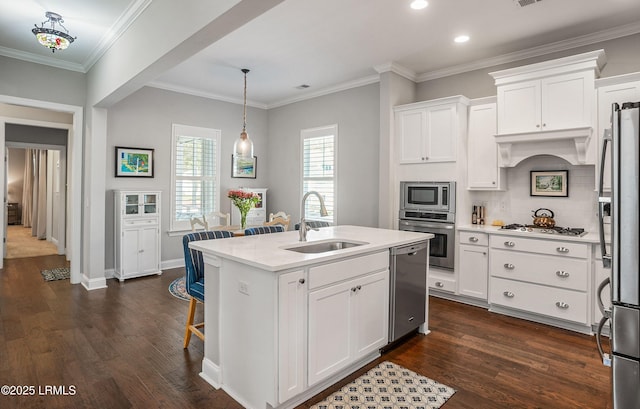 kitchen featuring sink, an island with sink, pendant lighting, stainless steel appliances, and white cabinets