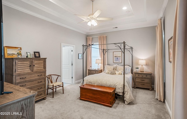 bedroom with ceiling fan, light colored carpet, ornamental molding, and a tray ceiling