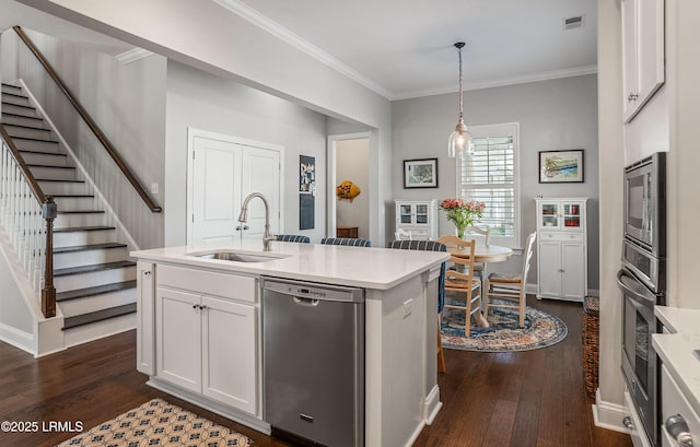 kitchen with white cabinetry, stainless steel appliances, decorative light fixtures, and sink