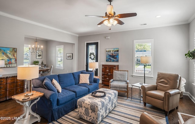 living room featuring dark wood-type flooring, crown molding, and ceiling fan with notable chandelier