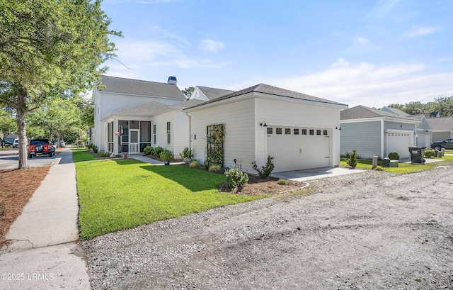 view of front of home featuring a garage, a front yard, and a sunroom