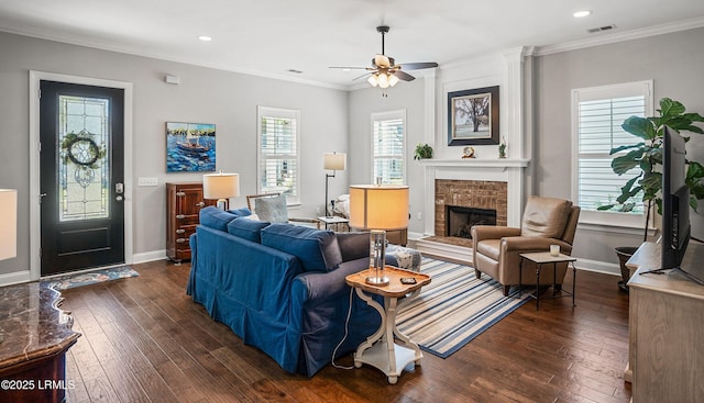 living room featuring a brick fireplace, crown molding, and dark hardwood / wood-style floors