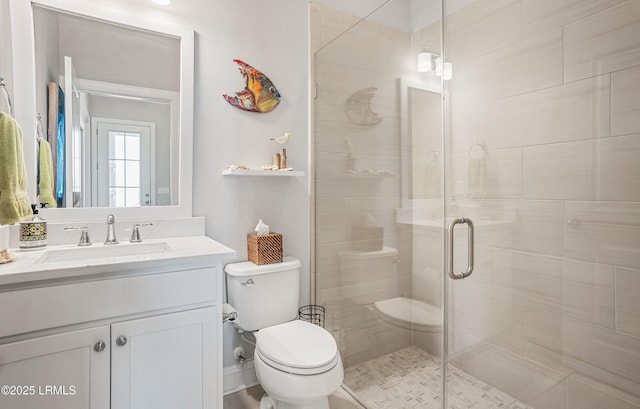 bathroom featuring vanity, toilet, and a shower with door