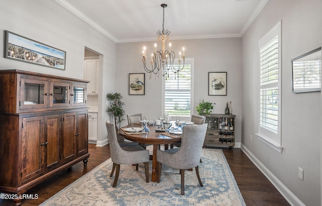 dining area featuring dark wood-type flooring, ornamental molding, and a chandelier