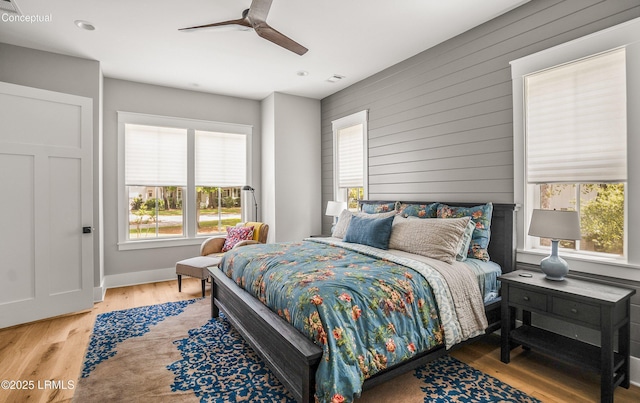 213 Old Plantation Dr W, Beaufort, SC 29907 - bedroom featuring multiple windows, wood finished floors, wooden walls, recessed lighting, and a ceiling fan