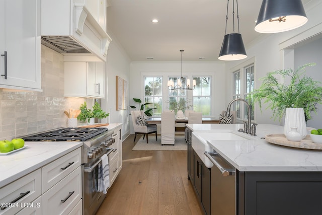 kitchen with white cabinetry, stainless steel appliances, premium range hood, and pendant lighting