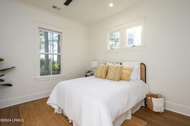 bedroom with ornamental molding, dark hardwood / wood-style floors, and ceiling fan