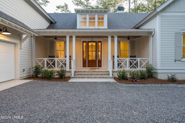 property entrance with a garage, ceiling fan, and a porch