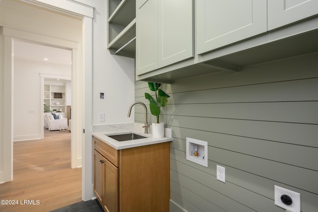 interior space featuring wood walls, sink, and light wood-type flooring