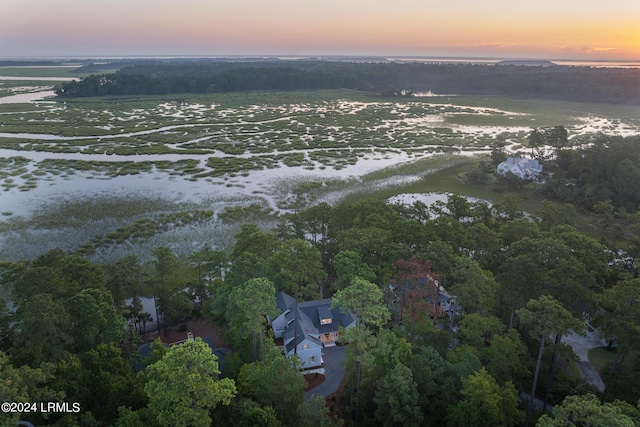 aerial view at dusk featuring a water view