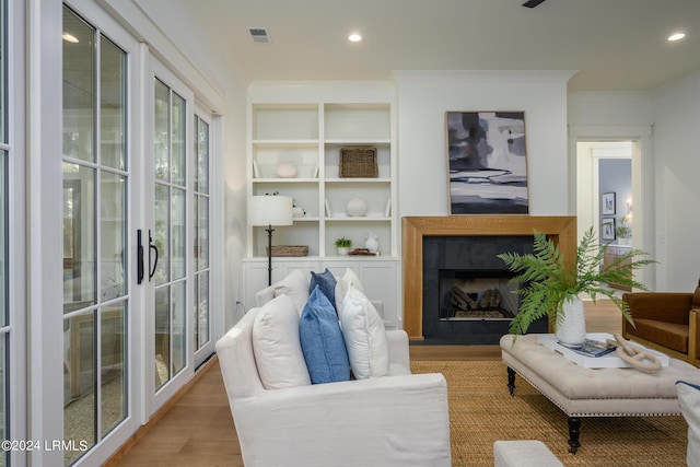 living room featuring ornamental molding and light hardwood / wood-style floors