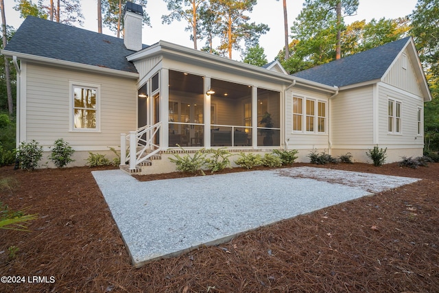 rear view of property featuring a sunroom