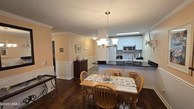 159 Beach Club Villa Dr Unit 159, Fripp Island, SC 29920 - dining area featuring a chandelier, dark wood-style flooring, wainscoting, and crown molding