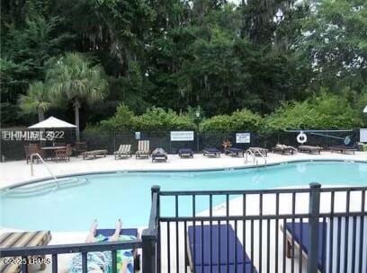 community pool featuring fence and a patio