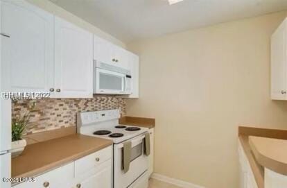 kitchen featuring tasteful backsplash, white appliances, white cabinets, and baseboards