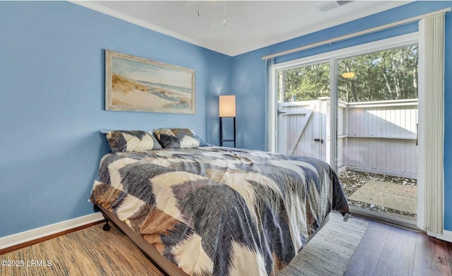 bedroom with crown molding, dark hardwood / wood-style floors, and access to outside