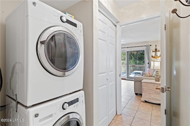 washroom featuring light tile patterned floors and stacked washer / drying machine