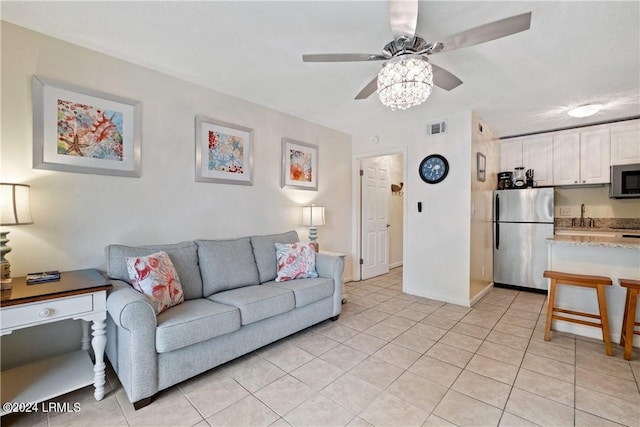 living room featuring light tile patterned floors, sink, and ceiling fan