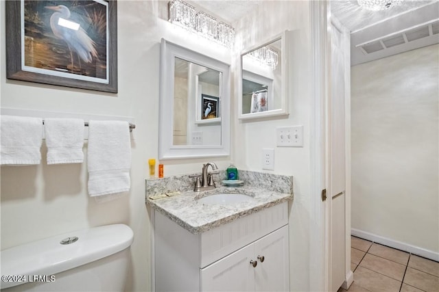 bathroom with tile patterned flooring, vanity, and toilet