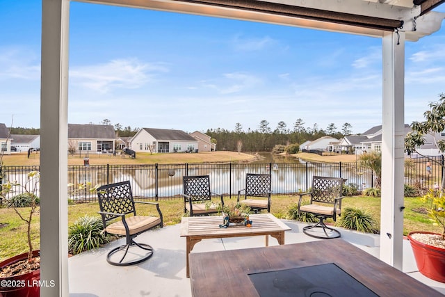 view of patio / terrace with a water view, a fenced backyard, and a residential view