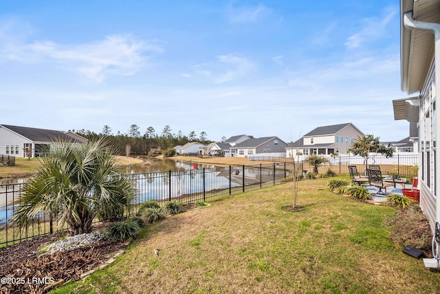 view of yard with a water view, a fenced backyard, and a residential view