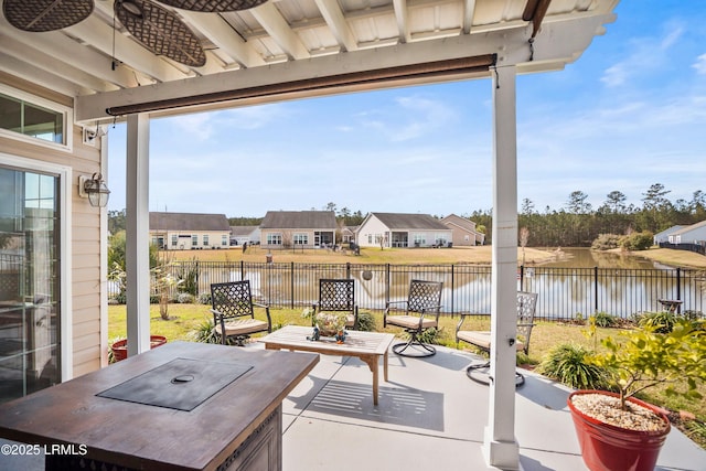 view of patio featuring a residential view, a water view, and a fenced backyard