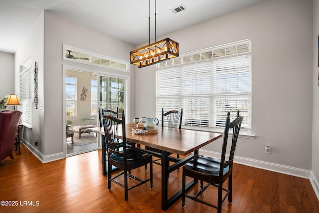 dining space featuring wood finished floors, visible vents, and baseboards