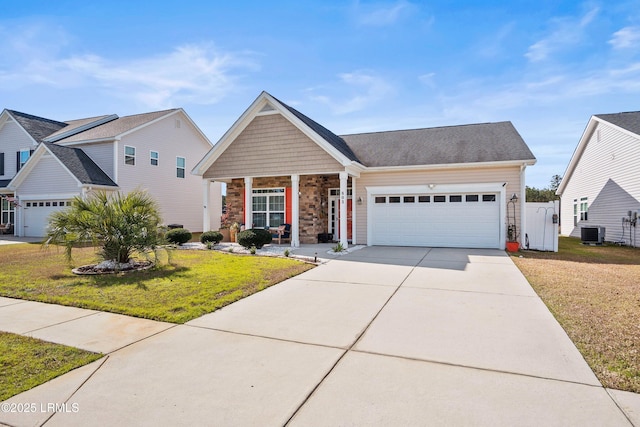 view of front of home with a garage, concrete driveway, a front yard, and central air condition unit