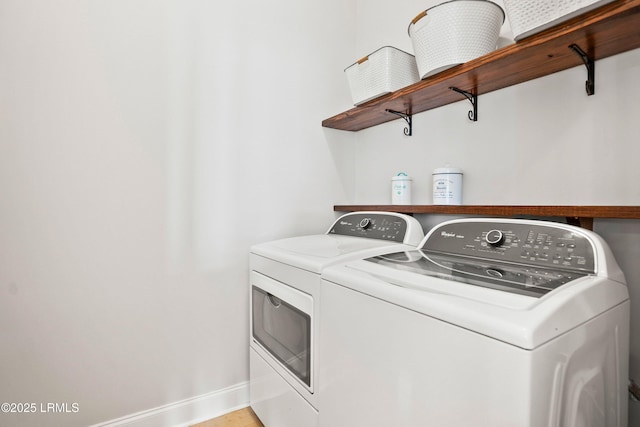 clothes washing area featuring laundry area, washing machine and clothes dryer, and baseboards