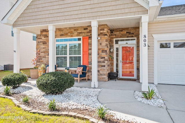 doorway to property featuring covered porch, stone siding, and central air condition unit