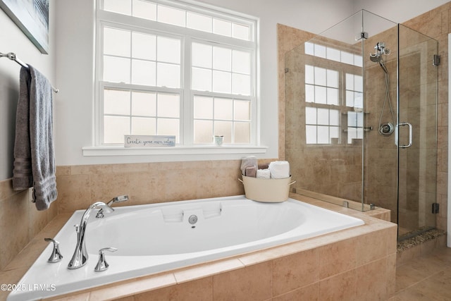 bathroom featuring plenty of natural light, a shower stall, and a bath