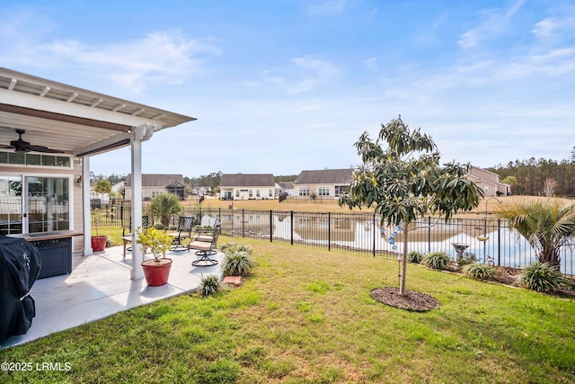 view of yard featuring a fenced backyard, a water view, a ceiling fan, a residential view, and a patio area