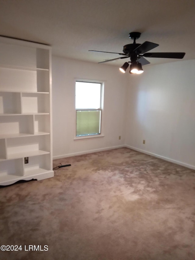 spare room with carpet floors, ceiling fan, and baseboards