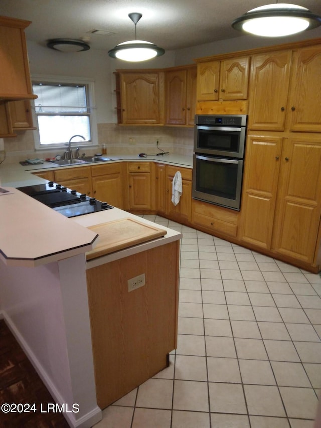 kitchen featuring light countertops, backsplash, double oven, light tile patterned flooring, and a sink