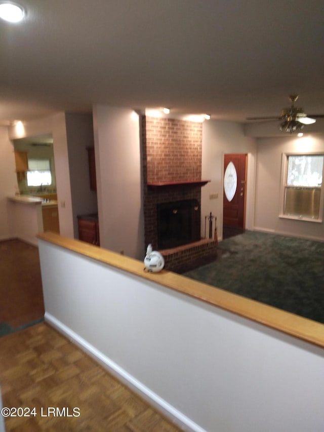 kitchen featuring a brick fireplace and dark wood-style flooring