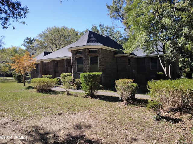 view of side of home featuring a yard and brick siding