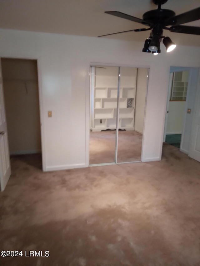 unfurnished bedroom featuring light carpet, ceiling fan, a closet, and baseboards