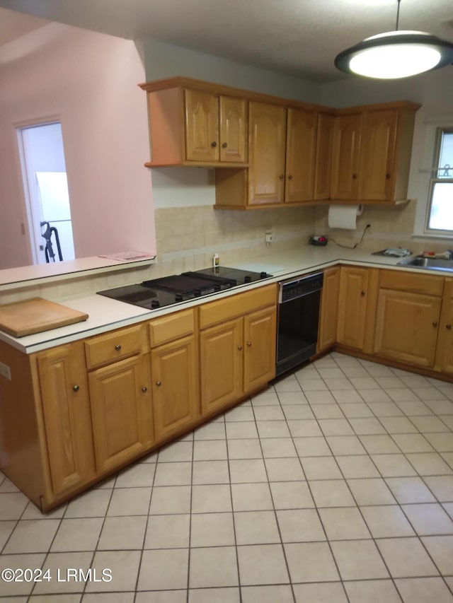 kitchen with a sink, light countertops, brown cabinets, decorative backsplash, and black appliances