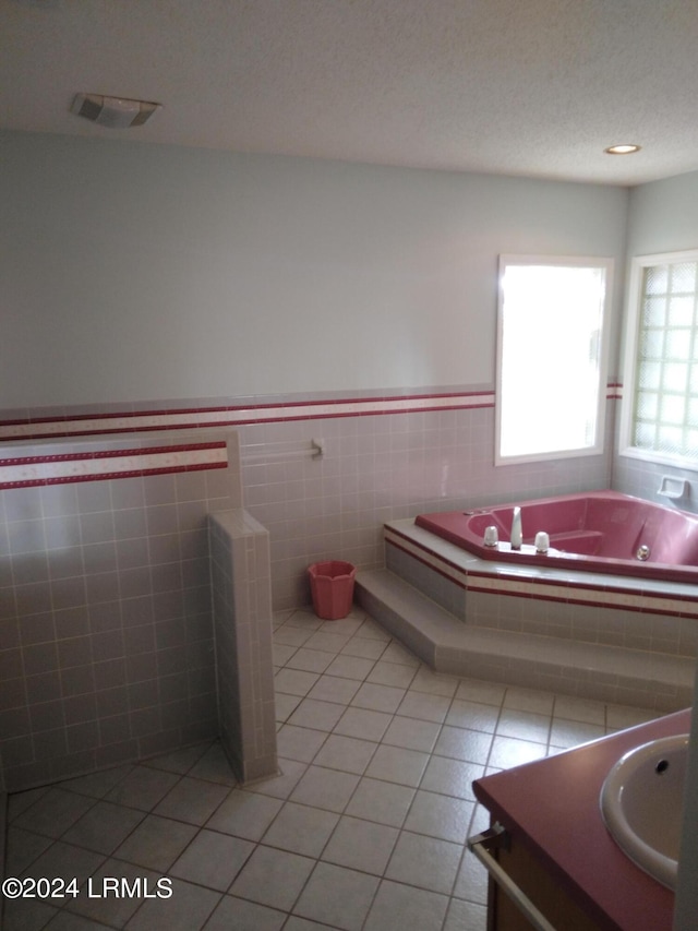 full bathroom with a textured ceiling, tile patterned flooring, vanity, visible vents, and a whirlpool tub