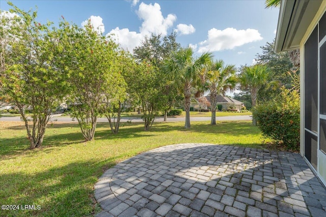 view of home's community with a lawn and a patio area