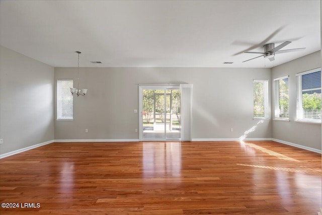 unfurnished room with wood-type flooring and ceiling fan with notable chandelier