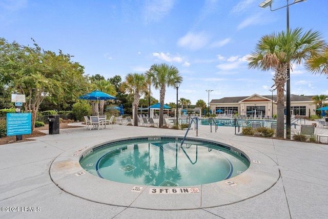 view of pool with a patio and a community hot tub