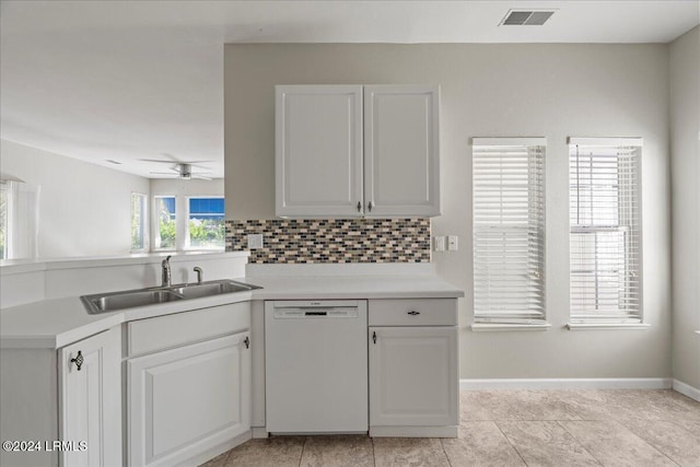 kitchen with light tile patterned flooring, tasteful backsplash, dishwasher, sink, and white cabinets