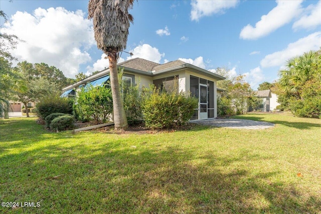 back of house featuring a yard and a sunroom