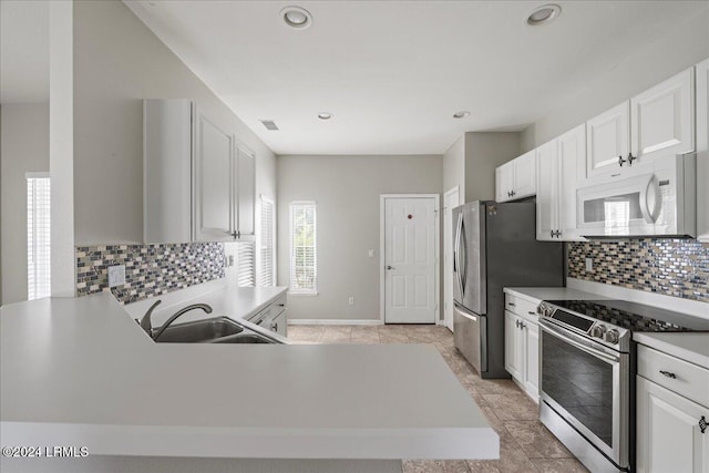 kitchen featuring white cabinetry, appliances with stainless steel finishes, kitchen peninsula, and sink