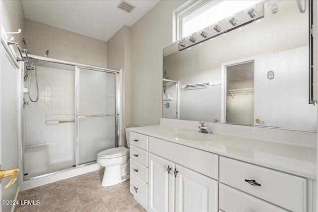 bathroom featuring vanity, an enclosed shower, and toilet